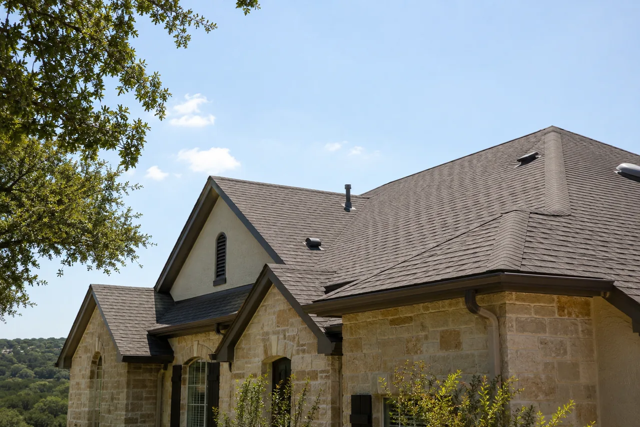 Architectural asphalt-shingle roof on a Central Texas home in strong summer sunlight